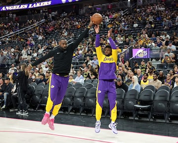 Padre e hijo se divierten durante el calentamiento previo al partido de pretemporada de la NBA entre Golden State Warriors y Los Angeles Lakers.