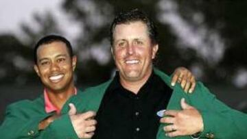 Phil Mickelson recibió de manos de Tiger Woods, anterior ganador del Masters, la chaqueta verde que le acredita como ganador de la edición del presente año.