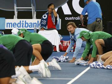 Tennis - Australian Open - Melbourne Park, Melbourne, Australia - 20/1/17 Japan&#039;s Kei Nishikori watches officials wipe the court dry during his Men&#039;s singles third round match against Slovakia&#039;s Lukas Lacko. REUTERS/Issei Kato