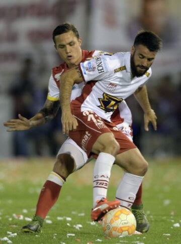 Argentina's Huracan defender Jose San Roman (front) vies for the ball with Colombia's Independiente Santa Fe midfielder Luis Seijas during their Copa Sudamericana 2015 final first leg football match at Tomas Duco stadium in Buenos Aires, Argentina, on December 2, 2015.  AFP PHOTO / JUAN MABROMATA