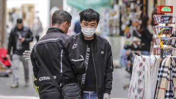 Un hombre con rasgos orientales se protege en la ciudad de Valencia con mascarilla del contagio por coronavirus en un mercadillo dos d&iacute;as despu&eacute;s de la suspensi&oacute;n de las Fallas, en Valencia (Espa&ntilde;a), a 13 de marzo de 2020.
 CORONAVIRUS;COVID-19;FALLAS;
 Rober Solsona / Europa Press
 13/03/2020 