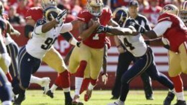 Aaron Donald #99 y Robert Quinn #94 placan a Colin Kaepernick en un duelo divisional de 2014.
