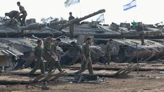 Israeli soldiers walk next to tanks, amid the ongoing conflict between Israel and the Palestinian Islamist group Hamas, near the Israel-Gaza border, in southern Israel, January 1, 2024. REUTERS/Violeta Santos Moura