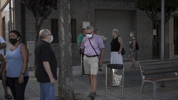 Imagen de varios ciudadanos de Cataluña caminando y portando mascarillas.