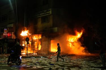 Una persona pasa junto a un banco incendiado y saqueado mientras las protestas lideradas por jóvenes que exigían reformas sanitarias y educativas se tornaron violentas en Salé, Marruecos.
Associated Press/LaPresse