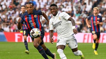 Barcelona's French defender Jules Kounde (L) fights for the ball with Real Madrid's Brazilian forward Vinicius Junior during the Spanish League football match between Real Madrid CF and FC Barcelona at the Santiago Bernabeu stadium on October 16, 2022. (Photo by PIERRE-PHILIPPE MARCOU / AFP)