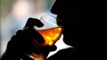 Persona ingiriendo alcohol vía Getty Images.