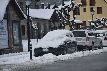 Vehículos repletos de nieve por las calles del Formigal.