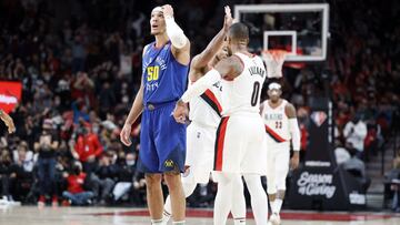 Nov 23, 2021; Portland, Oregon, USA; Portland Trail Blazers point guard Damian Lillard (0) celebrates with teammate CJ McCollum (3, behind) after a basket as Denver Nuggets power forward Aaron Gordon (50) reacts during the first half at Moda Center. Mandatory Credit: Soobum Im-USA TODAY Sports