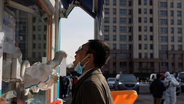 A man receives a throat swab test at a temporary COVID-19 testing center as the coronavirus disease (COVID-19) continues in Beijing, China, January 26, 2022.   REUTERS/Thomas Peter