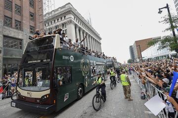 Los jugadores de los Bucks son aclamados por los aficionados en el autobús que recorre las calles de la ciudad de Milwaukee.