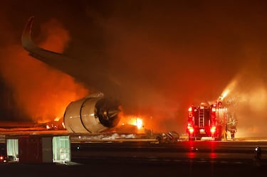 Bomberos trabajan para extinguir las llamas del avión de Japan Airlines en el Aeropuerto Internacional de Haneda en Tokio, Japón.