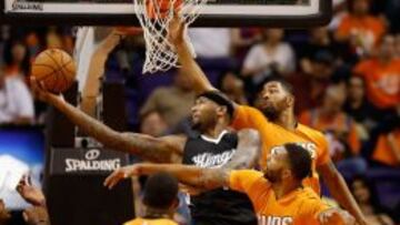 DeMarcus Cousins trata de anotar ante Markieff y Marcus Morris.