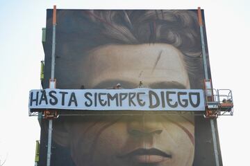 FLORENCE, ITALY - NOVEMBER 27:  Street artist Jorit while painting a mural dedicated to the politician and philosopher Antonio Gramsci pays a tribute to the football player Diego Armando Maradona with a banner that reads: 'Hasta siempre Diego' on November