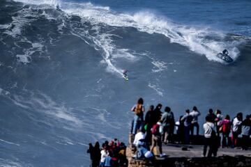 Varios curiosos alucinan con un surfista en Praia do Norte, Nazaré (Portugal) el 25 de febrero del 2022.