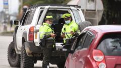 Police officers are seen next to vehicles at a checkpoint on a road entering Bogota, on June 18, 2022, a day before the presidential runoff election. - Colombians vote Sunday in a presidential runoff that features promises of radical change in a country saddled with widespread poverty, violence and other woes. After a tense campaign marked by claims of death threats against several candidates, opinion polls have leftist Gustavo Petro and businessman Rodolfo Hernandez neck-and-neck. (Photo by DANIEL MUNOZ / AFP) (Photo by DANIEL MUNOZ/AFP via Getty Images)