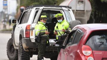 Police officers are seen next to vehicles at a checkpoint on a road entering Bogota, on June 18, 2022, a day before the presidential runoff election. - Colombians vote Sunday in a presidential runoff that features promises of radical change in a country saddled with widespread poverty, violence and other woes. After a tense campaign marked by claims of death threats against several candidates, opinion polls have leftist Gustavo Petro and businessman Rodolfo Hernandez neck-and-neck. (Photo by DANIEL MUNOZ / AFP) (Photo by DANIEL MUNOZ/AFP via Getty Images)