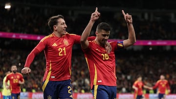 Spain's midfielder #16 Rodri celebrates scoring his team's third goal with Spain's forward #21 Mikel Oyarzabal during the international friendly football match between Spain and Brazil at the Santiago Bernabeu stadium in Madrid on March 26, 2024. Spain arranged a friendly against Brazil at the Santiago Bernabeu under the slogan "One Skin" to help combat racism. (Photo by Thomas COEX / AFP)