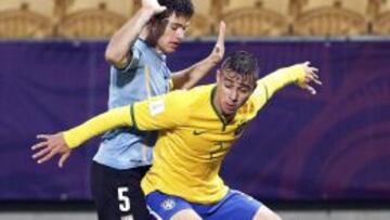 El jugador brasileño Joao Pedro (dcha) lucha por el balón con el uruguayo Nahitan Nandez