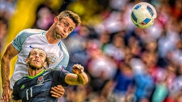 TOPSHOT - England&#039;s defender Gary Cahill vies for the ball with Wales&#039; forward Gareth Bale (front) during the Euro 2016 group B football match between England and Wales at the Bollaert-Delelis stadium in Lens on June 16, 2016. / AFP PHOTO / MART