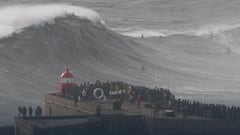 Lucas Chumbo Chianca surfeando una ola gigante en Praia do Norte, Nazaré (Portugal) con mucho público mirando desde el faro de San Miguel Arcángel.