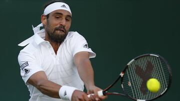 Marcos Baghdatis devuelve una bola ante Donald Young en su partido de primera ronda de Wimbledon 2015.