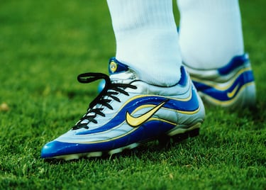 Semanas antes de que Brasil pisara el césped del Stade de France en 1998 para la final de la Copa del Mundo, su delantero estrella de 21 años, Ronaldo Nazário (R9), estrenó unas botas plateadas, azules y amarillas que nunca se habían visto en el fútbol: las Mercurial. El de Río de Janeiro no tuvo mucha suerte con ellas puestas ya que su combinado nacional perdió 0-3 frente a Francia.
