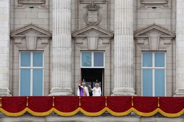 El rey Carlos III y la reina Camila saludan desde el balcón a los asistentes al Palacio de Buckingham.