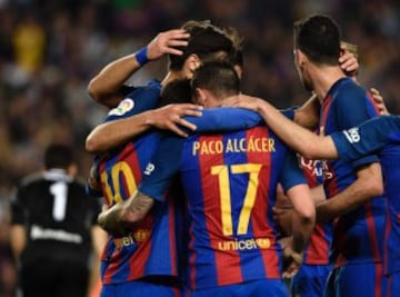 Barcelona's forward Paco Alcacer (C) celebrates with teammates after scoring a goal  during the Spanish league football match FC Barcelona vs Real Sociedad at the Camp Nou stadium in Barcelona on April 15, 2017. / AFP PHOTO / LLUIS GENE