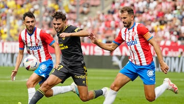 GIRONA, 03/09/2023.- Cristhian Stuani (d) del Girona FC disputa un balón ante Munir (c) de las Palmas durante el Partido de Liga en Primera División entre el Girona FC - Las Palmas, en el estadio municipal de Montilivi, este domingo. EFE/ David Borrat
