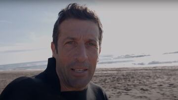 El ex ciclista profesional Juan Antonio Flecha, con traje de neopreno, hablando a c&aacute;mara ante la playa -con olas- de Castelldefels (Barcelona).