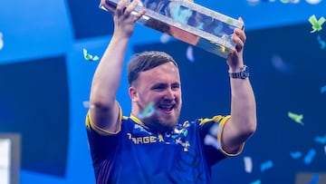 El jugador inglés de dardos Luke Littler levanta el trofeo de campeón del World Grand Prix de Dardos tras ganar en la final a Luke Humphries.