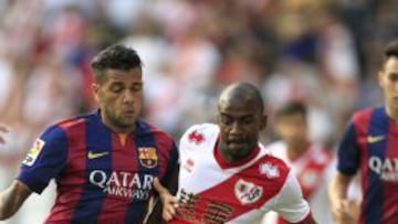 El delantero francés del Rayo Vallecano Gaël Kakuta (d) pelea un balón con el defensa del Barcelona Dani Alves
