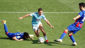 Los jugadores del Eibar, el polaco Damian Kadzior y el portugu&eacute;s Paulo Oliveira intentan arrebatar el bal&oacute;n a Emre Mor, delantero turco del Celta de Vigo, durante el partido de la primera jornada de la LaLiga Santander que disputan este s&aa