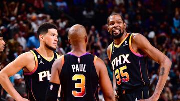 PHOENIX, AZ - APRIL 6: Devin Booker #1, Chris Paul #3 and Kevin Durant #35 of the Phoenix Suns looks on during the game on April 6, 2023 at Footprint Center in Phoenix, Arizona. NOTE TO USER: User expressly acknowledges and agrees that, by downloading and or using this photograph, user is consenting to the terms and conditions of the Getty Images License Agreement. Mandatory Copyright Notice: Copyright 2023 NBAE (Photo by Barry Gossage/NBAE via Getty Images)