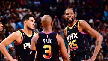 PHOENIX, AZ - APRIL 6:  Devin Booker #1, Chris Paul #3 and Kevin Durant #35 of the Phoenix Suns looks on during the game on April 6, 2023 at Footprint Center in Phoenix, Arizona. NOTE TO USER: User expressly acknowledges and agrees that, by downloading and or using this photograph, user is consenting to the terms and conditions of the Getty Images License Agreement. Mandatory Copyright Notice: Copyright 2023 NBAE (Photo by Barry Gossage/NBAE via Getty Images)