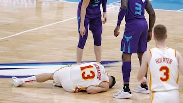 CHARLOTTE, NORTH CAROLINA - JANUARY 09: Bogdan Bogdanovic #13 of the Atlanta Hawks goes to the floor with an injury as LaMelo Ball #2 and Terry Rozier #3 of the Charlotte Hornets look on during the second quarter of their game at Spectrum Center on January 09, 2021 in Charlotte, North Carolina. NOTE TO USER: User expressly acknowledges and agrees that, by downloading and or using this photograph, User is consenting to the terms and conditions of the Getty Images License Agreement.   Jared C. Tilton/Getty Images/AFP
 == FOR NEWSPAPERS, INTERNET, TELCOS &amp; TELEVISION USE ONLY ==