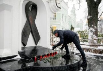 Un hombre colocando flores en un monumento en memoria de las v¨ªctimas del Sida en Kiev, Ucrania.