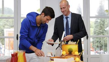 Novak Djokovic parte una tarta junto con Guy Forget, director de Roland Garros, para celebrar los 29 a&ntilde;os cumplidos por el tenista serbio este domingo.