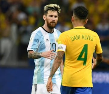 Brazil's Dani Alves (R) greets Argentina's Lionel Messi after defeating Argentina 3-0 in their 2018 FIFA World Cup qualifier football match in Belo Horizonte, Brazil, on November 10, 2016. / AFP PHOTO / VANDERLEI ALMEIDA