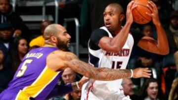 Carlos Boozer defiende a Al Horford.