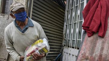 BOGOTA, COLOMBIA - APRIL 23: A man holds a bag of food aid as Colombian military visit the impoverished slum at El Codito neighbourhood  handing out family food baskets during government-ordered obligatory quarantine on April 23, 2020 in Bogota, Colombia. President of Colombia Ivan Duque has announced Monday April 20th the extension of the national quarantine until May 11th to halt the spread of the coronavirus (COVID-19).  (Photo by Guillermo Legaria/Getty Images)