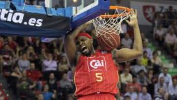 El pívot estadounidense del CAI Zaragoza Joseph Jones hace un mate ante el alero del Estudiantes Xavi Rabaseda (d).