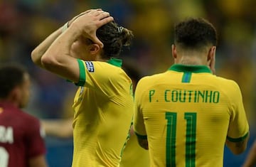 Brazil's Filipe Luis (L) and Philippe Coutinho react during their Copa America football tournament group match against Venezuela at the Fonte Nova Arena in Salvador, Brazil, on June 18, 2019. (Photo by Juan MABROMATA / AFP)