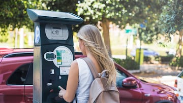Mujer utilizando un parquímetro
