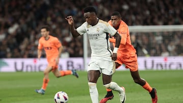 Real Madrid's Brazilian forward #07 Vinicius Junior (L) is challenged by Valencia's Spanish defender #03 Cristhian Mosquera during the Spanish league football match between Real Madrid CF and Valencia CF at the Santiago Bernabeu stadium in Madrid on November 11, 2023. (Photo by Thomas COEX / AFP)