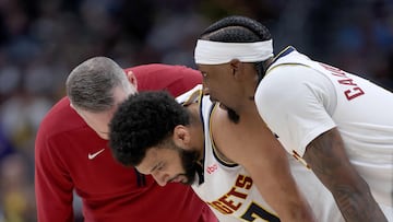 DENVER, COLORADO - MARCH 21: Head coach Michael Malone of the Denver Nuggets checks on Jamal Murray #27 after a hard hit against the New York Knicks during the fourth quarter at Ball Arena on March 21, 2024 in Denver, Colorado. NOTE TO USER: User expressly acknowledges and agrees that, by downloading and or using this photograph, User is consenting to the terms and conditions of the Getty Images License Agreement.   Matthew Stockman/Getty Images/AFP (Photo by MATTHEW STOCKMAN / GETTY IMAGES NORTH AMERICA / Getty Images via AFP)