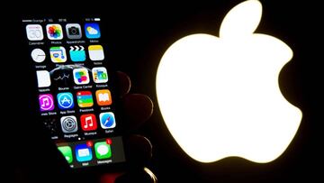This file photo taken on January 26, 2016 shows a hand holding an iphone next to the Apple logo on January 30, 2015 in New York City.
 The European Union on August 30, 2016 orders Apple to pay a record 13 billion euros in back taxes in Ireland, saying deals allowing the US tech giant to pay almost no tax were illegal.
 In a ruling that is set to anger Washington, the European Commission says the world&#039;s most valuable company avoided tax bills on almost all its profits in the bloc under the arrangements with the Irish government.
  / AFP PHOTO / GETTY IMAGES NORTH AMERICA / Andrew Burton