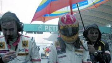 <b>A CUBIERTO. </b>Alonso caminaba por la recta de meta protegido por el paraguas de su preparador.