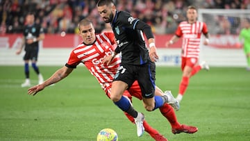 Yannick Carrasco avanza con el balón ante la oposicióon de Oriol Romeu.